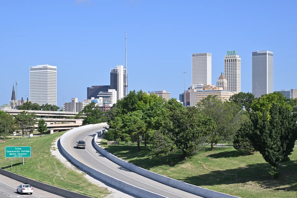 Downtown Tulsa skyscrapers rising beyond a tree-lined park