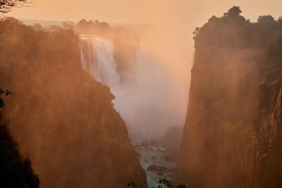 The misty gorge of Victoria Falls at sunset