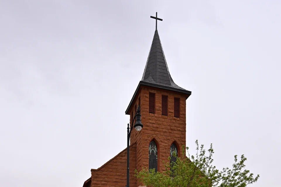 A historic red-brick church with a pointed steeple in Winslow