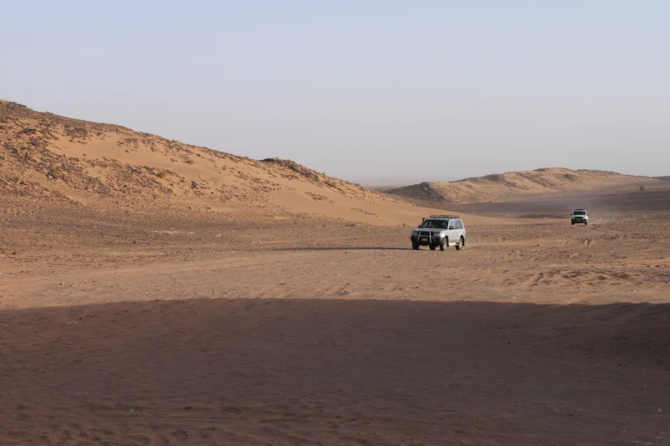 Wide sand dunes and a distant desert track near Zagora