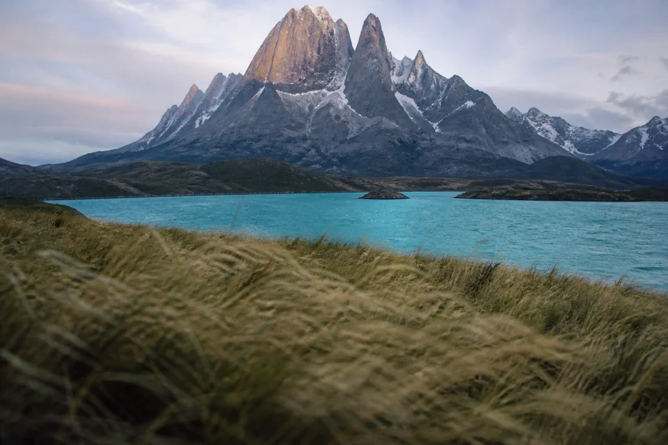 Sharp granite spires rising above a turquoise lake at dawn in Chile