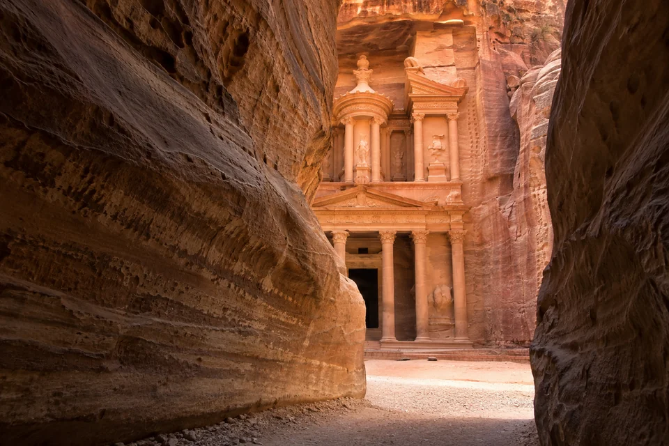 The Treasury of Petra seen through the narrow walls of the Siq canyon
