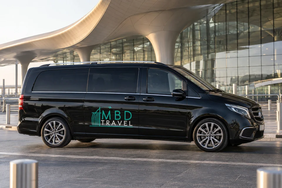 Black Mercedes-Benz Vito with MBD Travel livery outside AUH Terminal A in morning light, visualization