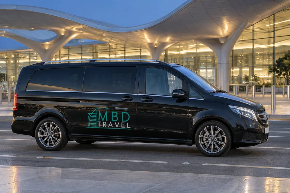 Black Mercedes-Benz Vito with MBD Travel livery outside AUH Terminal A at dusk, visualization