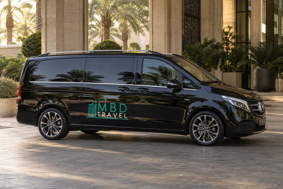 Black Mercedes-Benz Vito with MBD Travel livery at a Dubai hotel entrance in late afternoon, visualization