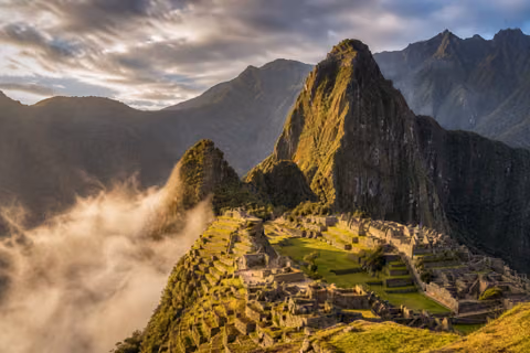 Gün doğarken Machu Picchu’nun teraslı kalıntıları ve vadiyi dolduran sis